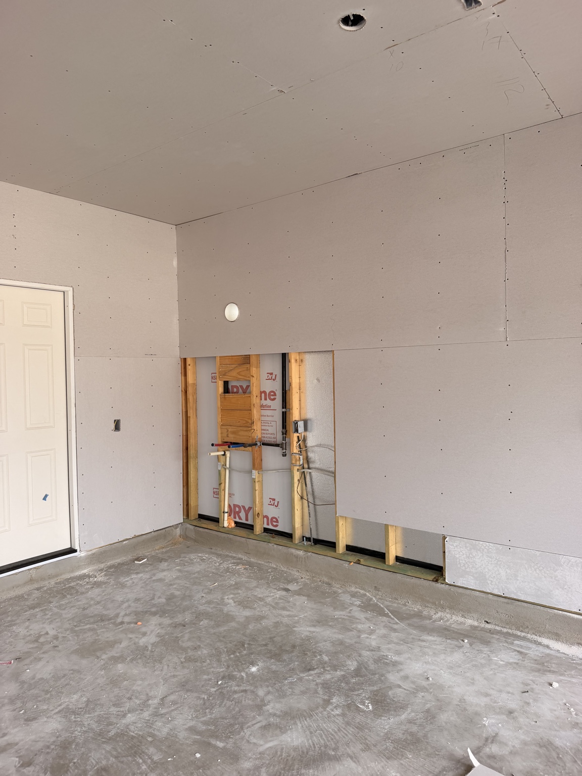 Sheetrock hanging in progress on garage walls and ceiling