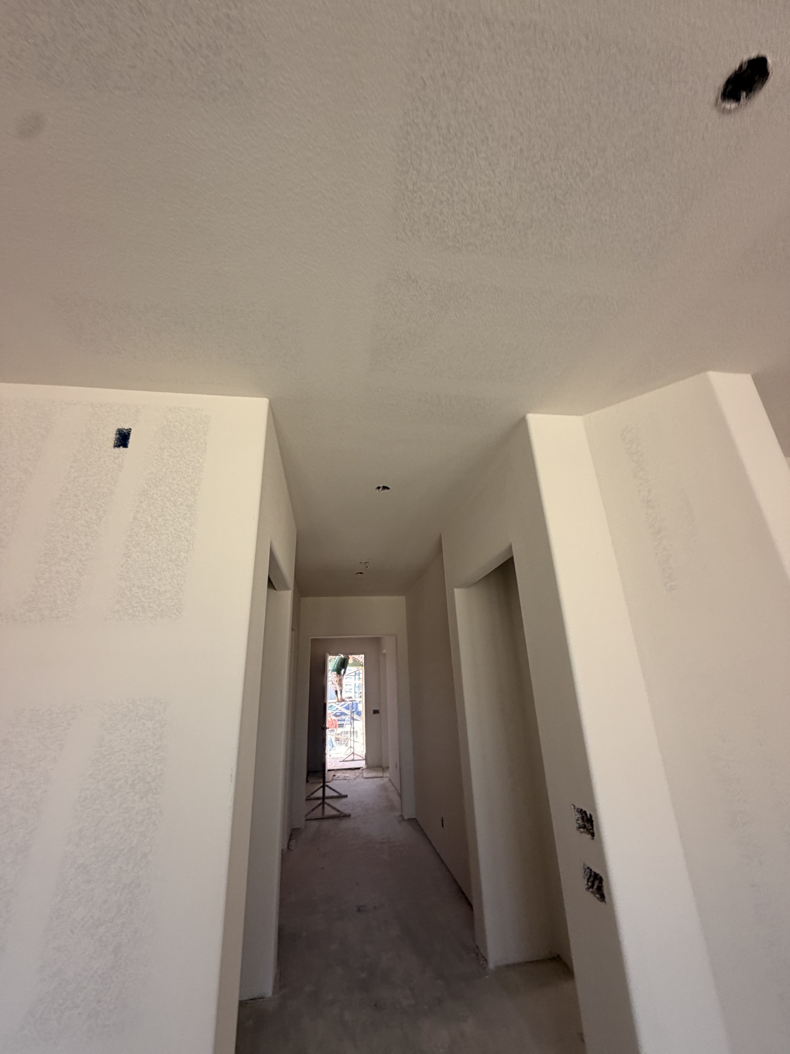 Textured drywall walls and ceiling in a residential hallway